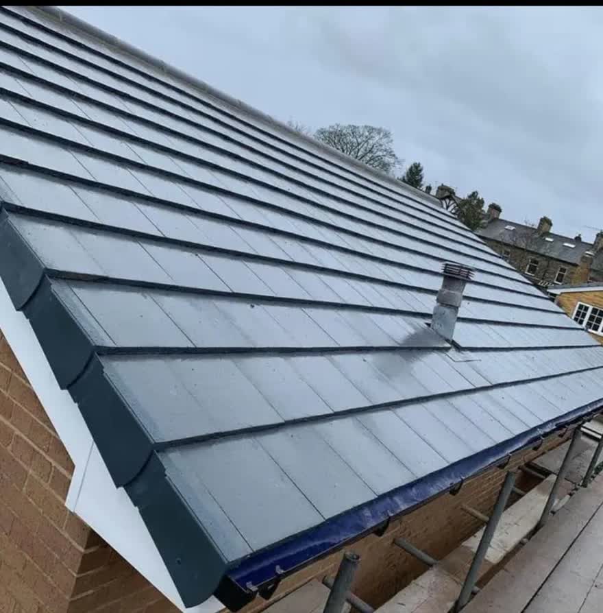 New lead work dressed into a grey tiled roof beside a flat section