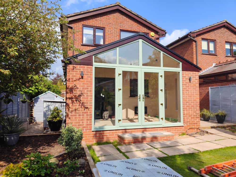 Brick garden room with a glazed gable end and insulation boards ready on the patio