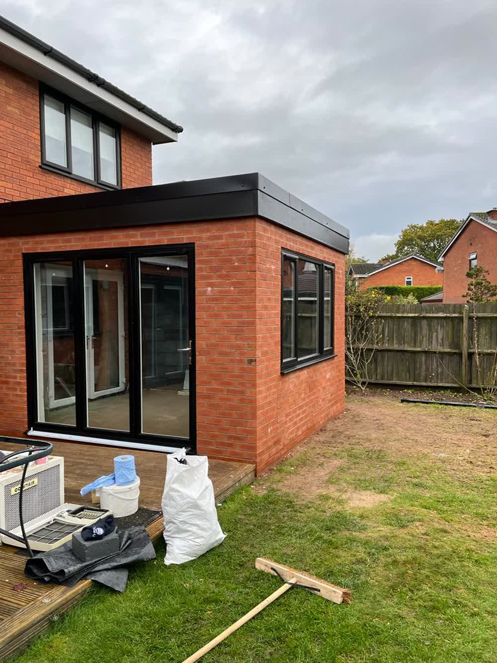 Modern flat roofed brick extension with dark fascia and bifold doors