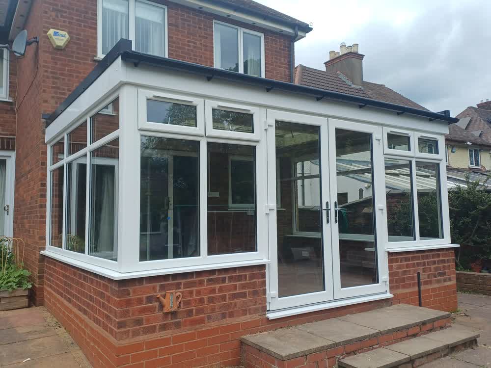Conservatory with a new tiled roof and white uPVC frames